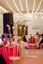 Warm and inviting scene featuring tables draped in pink tablecloths, adorned with lit candles