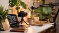 Cozy workspace with camera, laptop, microphone, and indoor plants Royalty Free Stock Photo