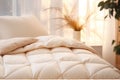 Warm ivory duvet quilt lying on bed in cozy bedroom. Preparing for winter season, household, domestic activities, hotel