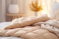 Warm ivory duvet quilt plaid lying on bed in cozy bedroom. Preparing for winter season, household, domestic activities