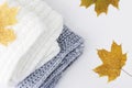 Warm knitted sweaters and fallen autumn maple leaves. autumn concept. Flat lay, top view, copy space. Royalty Free Stock Photo
