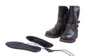 Warm leather boots and insoles with electric heating. USB Insoles with wires and black winter boots isolated on white background. Royalty Free Stock Photo