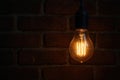 A warm light bulb against the background of a brick wall. Space for text. Royalty Free Stock Photo