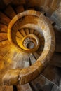 Warm light enhances the hypnotic spiral of an elegant stone staircase, invoking a sense of infinite descent. Royalty Free Stock Photo