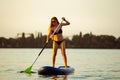 Young attractive woman standing on paddle board, SUP. Active life, sport, leisure activity concept Royalty Free Stock Photo