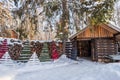 A warm looking cottage at the middle of a snowy winter forest. Firewood stacked in piles, covered with snow. cutted Royalty Free Stock Photo