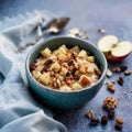 Warm oatmeal bowl with apples, walnuts, raisins, honey, and spices on rustic table in soft light Royalty Free Stock Photo