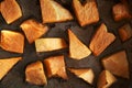 Warm pieces of orange pumpkin baked in oven on baking sheet, simple artisan rustic meal, top view above, close-up