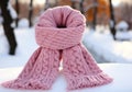 Warm pink wool scarf in the snow. Winter time. AI generated