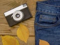 Warm and romantic autumn - jeans, old retro camera, leaves