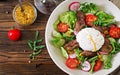 Warm salad from chicken liver, radish, cucumber, tomato and egg poached Royalty Free Stock Photo