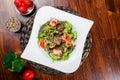 Warm salad with chicken liver, tomatoes, lettuce leaves, broccoli on wooden table Royalty Free Stock Photo