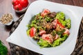 Warm salad with chicken liver, tomatoes, lettuce leaves, broccoli on wooden table. Healthy food. Royalty Free Stock Photo