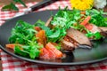 Warm salad, Duck with arugula, tasty, fashionable food, new dish serving. Wooden rustic background. Top view