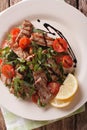 Warm salad of grilled beef with arugula and tomatoes close-up. V