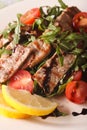Warm salad of grilled beef with arugula and tomatoes macro. vert