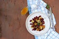 Warm salad of grilled Jerusalem artichoke and boiled red beans with olive oil and vinegar dressing on a white clay plate Royalty Free Stock Photo