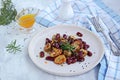 Warm salad of grilled Jerusalem artichoke and boiled red beans with olive oil and vinegar dressing on a white clay plate