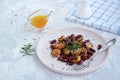 Warm salad of grilled Jerusalem artichoke and boiled red beans with olive oil and vinegar dressing on a white clay plate