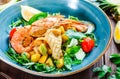 Warm salad with seafood, langoustine, mussels, shrimps, squid, scallops, mango, pineapple, avocado