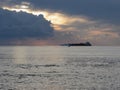 Warm sea sunset with cargo ship and a small fishing boat at the horizon . Giants cumulonimbus clouds are in the sky. Tuscany, Ital Royalty Free Stock Photo