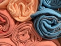 Warm soft rugs of various pastel colors rolled into rollers. End view. Texture, background