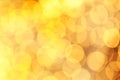 Warm sparkling lights festive yellow background. Abstract golden twinkled bright bokeh glitter