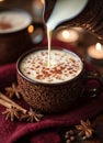 Warm spiced drink being poured into a patterned cup on a cozy table setting in the evening Royalty Free Stock Photo