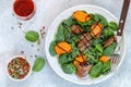 Warm spinach salad with chicken liver and baked pumpkin with spices and balsamic