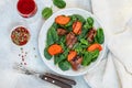 Warm spinach salad with chicken liver and baked pumpkin with spices and balsamic