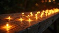 Warm string lights glow on a rustic wooden table at night. The blurred background shows more bokeh lights creating a cozy and Royalty Free Stock Photo