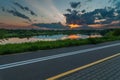 Warm summer evening. Beautiful sunset over the river. City cycle path along the river in the foreground Royalty Free Stock Photo