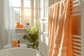 Warm sunlight in a cozy bathroom with peach towels on a rack Royalty Free Stock Photo
