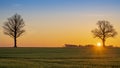 Warm sunrise over open agriculture field with sun