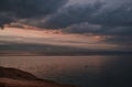 Warm sunset with large clouds on Lake Baikal, in front of the beach, behind mountains Royalty Free Stock Photo