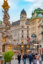 Warm sunset over busy with tourists famous Graben shopping street near Stephans square Stephansplatz in historical touristic