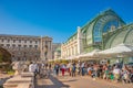 Warm sunset over busy with tourists streets at Alberina, Palmenhaus and Neue Burg Palace garden, near Hofburg Palace in historical