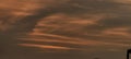 Warm sunset sky with swirling clouds, subtle city skyline, dramatic atmospheric lighting, and a rich color palette. Royalty Free Stock Photo