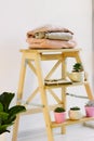 Warm sweaters lie on a wooden shelf.