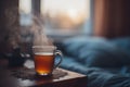 Warm tea sits in glass cup on table beside bed with soft sunlight streaming in window during evening hours Royalty Free Stock Photo