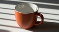 Warm terracotta mug with handle on white surface under morning light Royalty Free Stock Photo