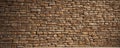 Warm-toned stacked stone wall, horizontal orientation, sunlight highlights, brown, rock Royalty Free Stock Photo
