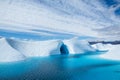 Warm weather melting the ice of the Matanuska Glacier into a large blue pool. An ice cave cuts into the ice, also flooded with the Royalty Free Stock Photo