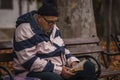 Warm-weather middle-aged man sits in the park and reads a book in Bourgas / Bulgaria / 10.14.2014 / Royalty Free Stock Photo