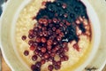 Warm wheat porridge with red currants and blueberry jam.A close-up of a plate of wheat porridge for a healthy gluten