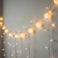 Warm white string lights hang against a wall, featuring both round globes and small
