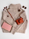 A warm wool sweater and an old camera in a brown case. Book, cones and chestnuts