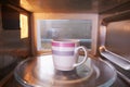 Warming Cup Of Coffee Inside Microwave Oven