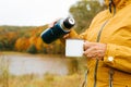 Warming drink in cold weather, autumn lifestyle. Close-up senior woman pouring hot tea from thermos Royalty Free Stock Photo