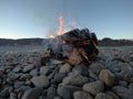 Warming fire on frozen cold white river shore